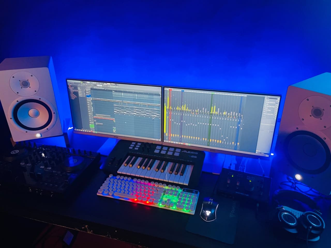 Blue-lit audio workstation and studio monitors