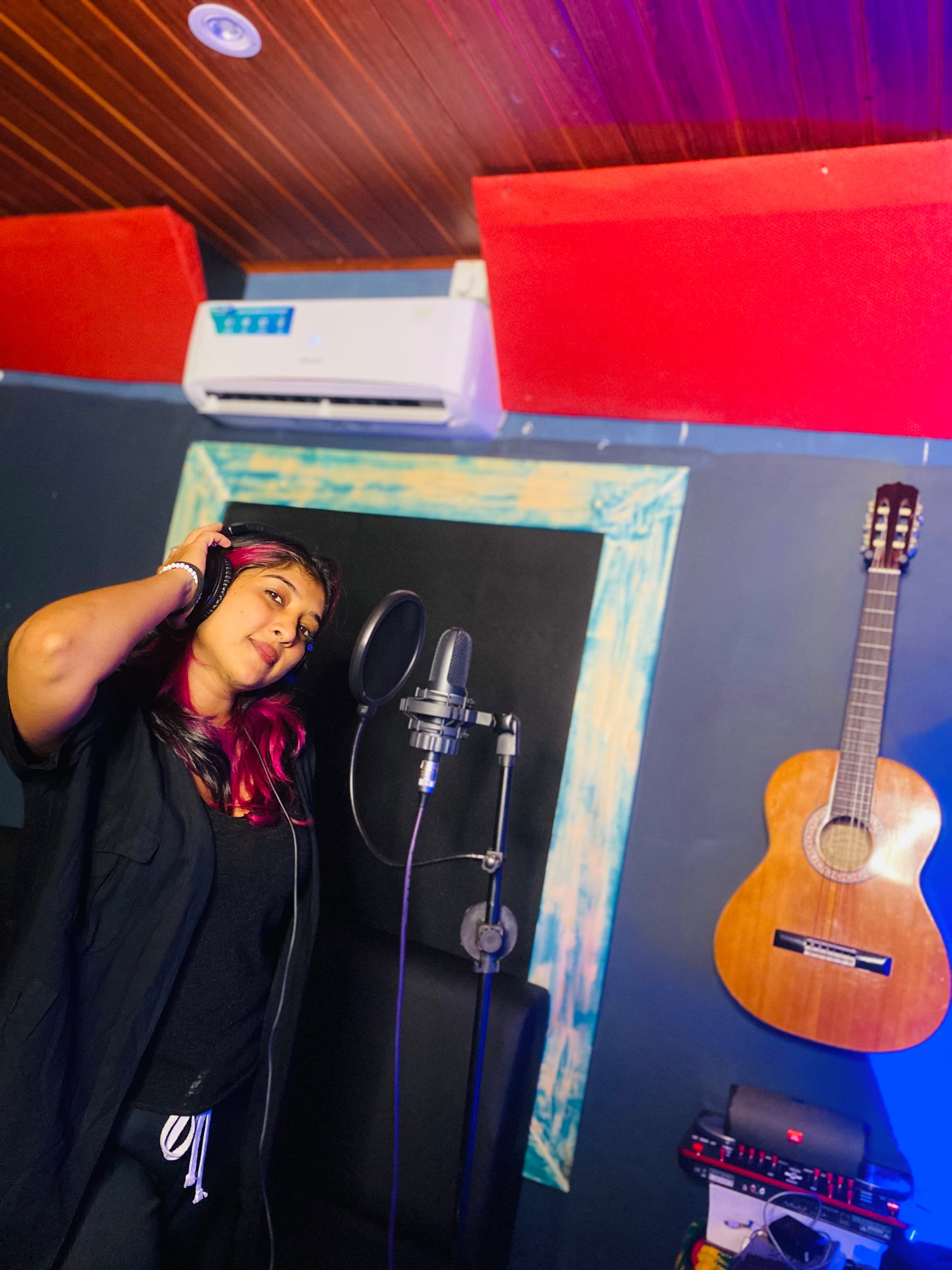 Artist wearing headphones at a recording microphone